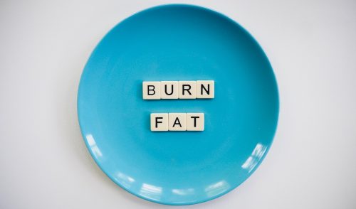 Bogstavsbrikker liggende i blå tallerken med ordet "burn fat"