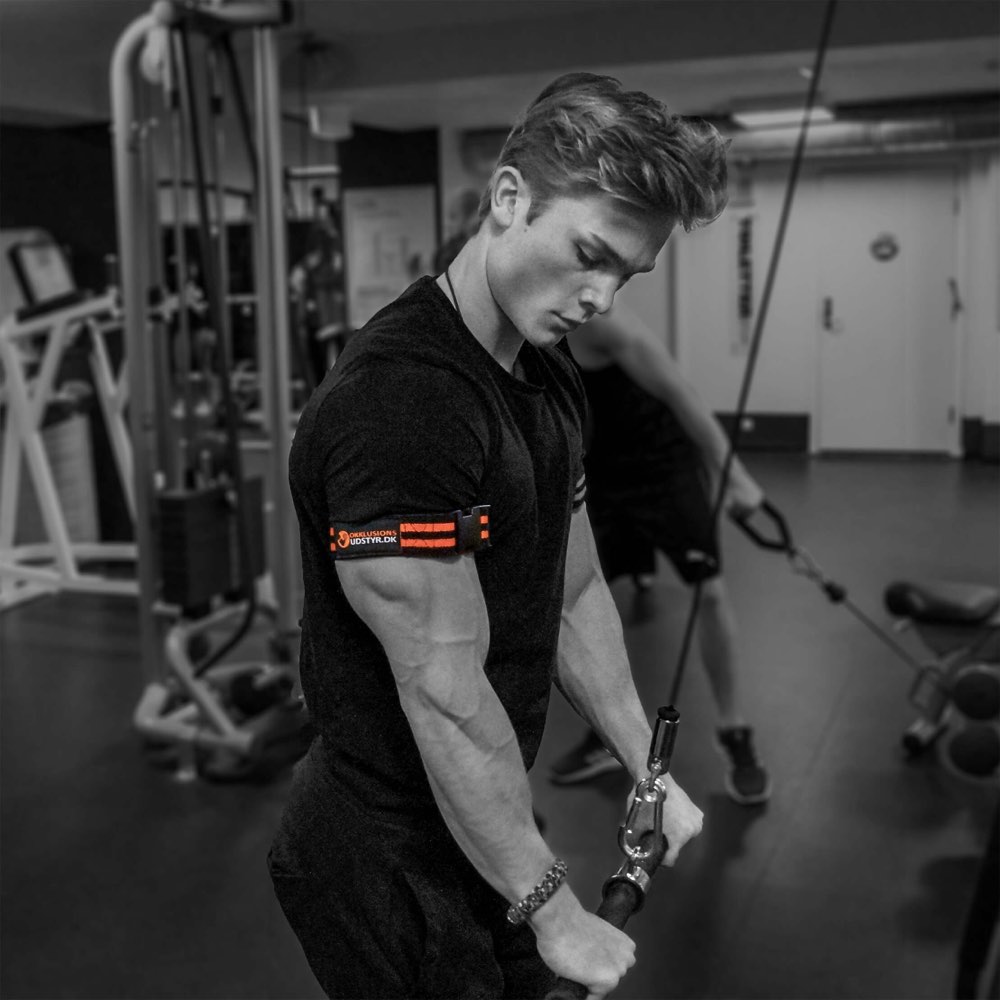 Mand træner triceps med okkluionsbånd fra Okklusionsudstyr.dk monteret på armene